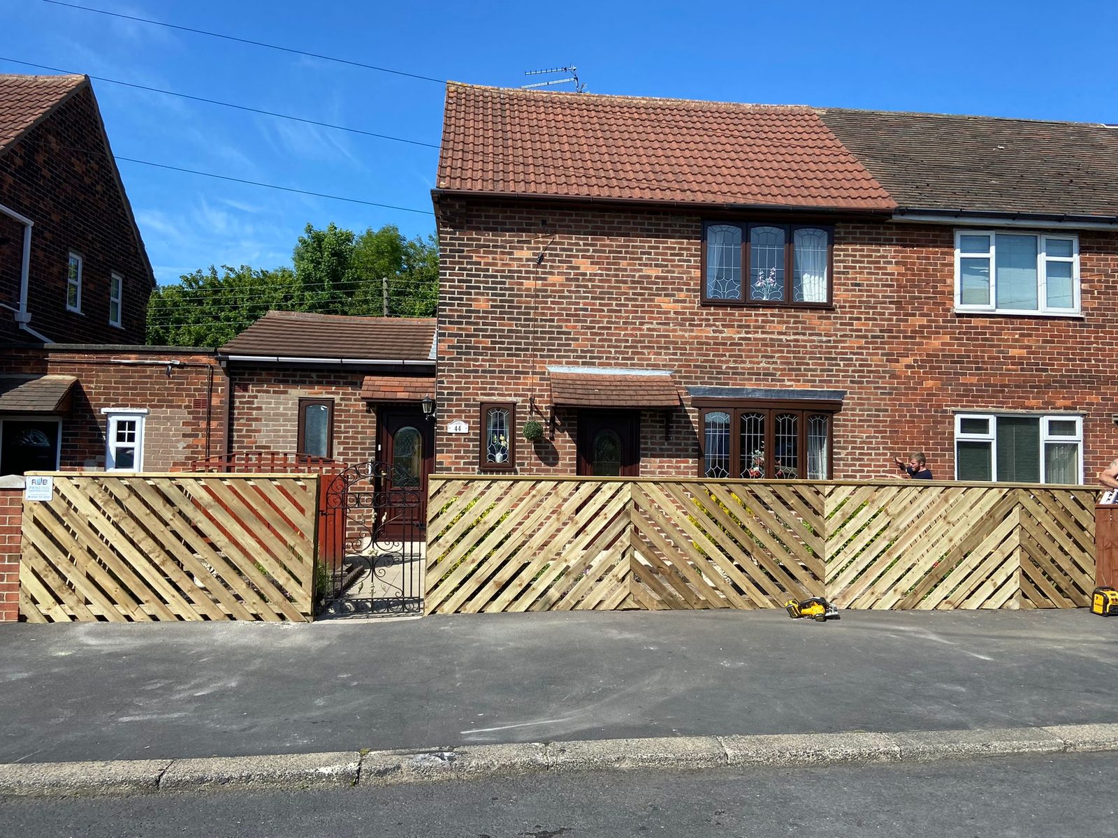 Lattice-topped timber fence panels along the front of a house