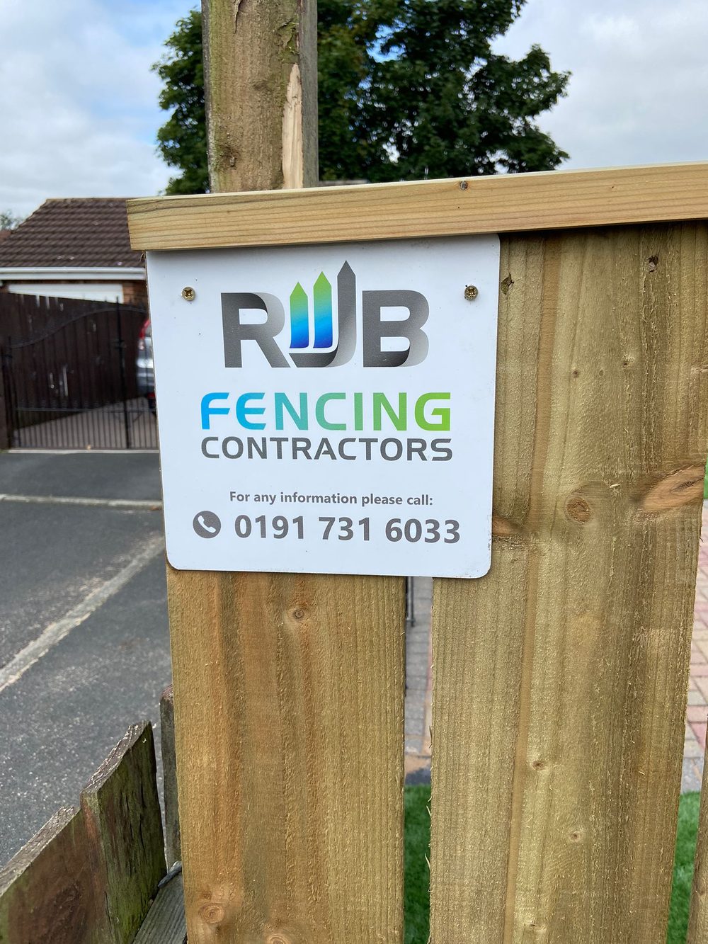 The RJB Fencing Contractors sign fixed to a new fence post